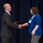 Doctor Potteiger shaking hands with an award recipeint in a blue cardigan